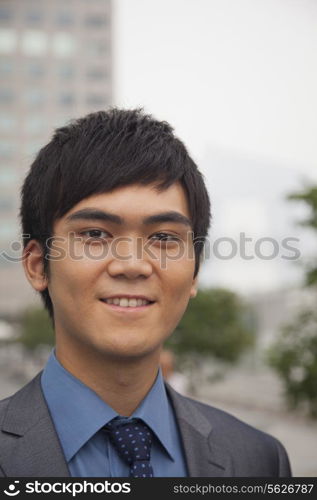Young business man smiling, portrait