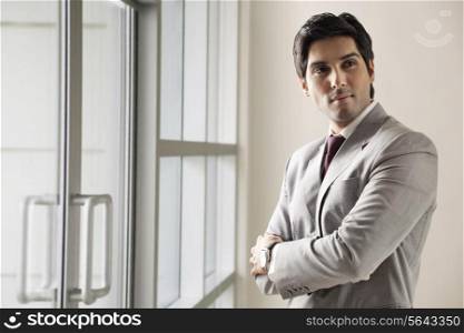 Young business man standing with arms crossed