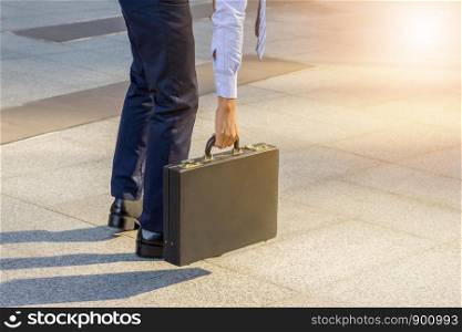 Young business man standing with his back carrying a briefcase city background, Start and forward Concept.