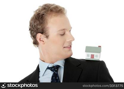 Young business man with house model - real estate concept. Isolated on white