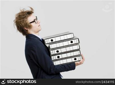 Young business man with nerd glasses and carrying a bunch of folders