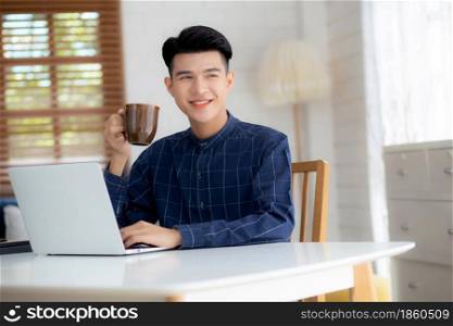 Young business man working from home with laptop computer on desk, freelance male sitting stay home using notebook for communication and relax on table, entrepreneur in startup business, new normal.