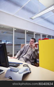 young business man working on computer and talking by phone on modern office indoors