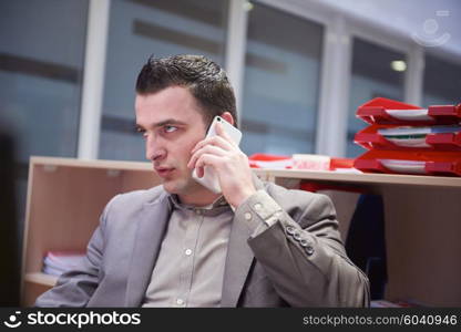 young business man working on computer and talking by phone on modern office indoors