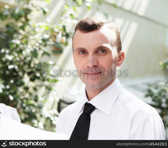 young business man working with documents in garden