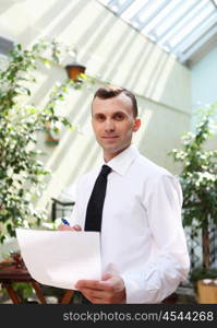 young business man working with documents in garden