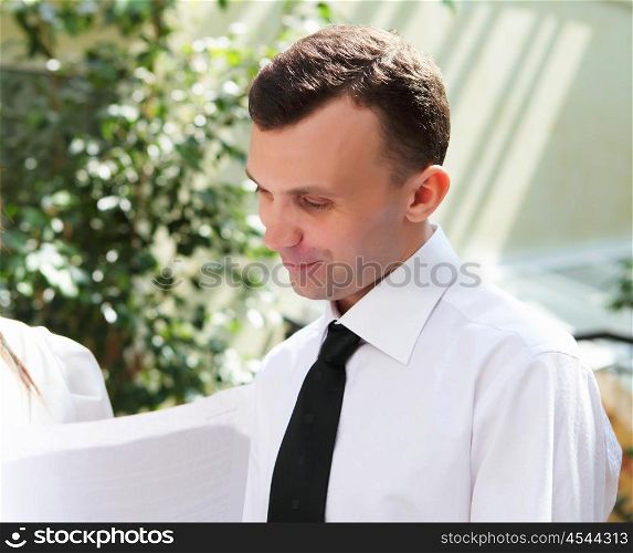 young business man working with documents in garden