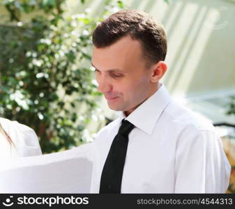 young business man working with documents in garden