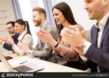 Young business people clapping their hands in office