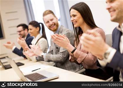 Young business people clapping their hands in office