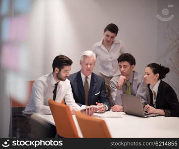 Young business people group on meeting at modern startup office with senior manager. Team leader looking presentation and results on tablet and laptop computer.