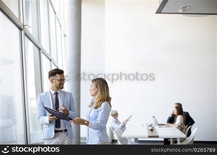 Young business people looking a file in a modern office