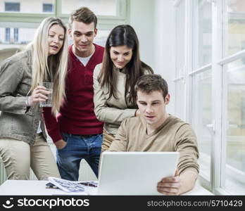 Young business people looking at laptop in meeting