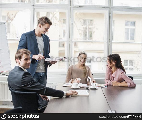 Young business people looking at laptop in meeting