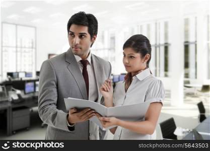Young business people looking away while holding document