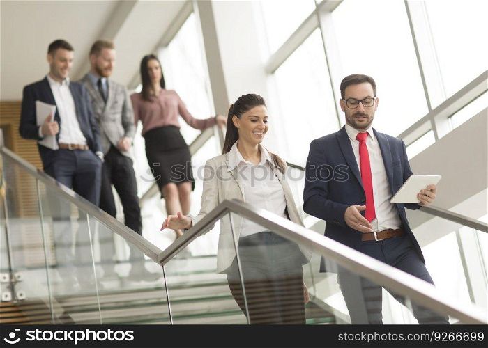 Young business people on stairs with tablet
