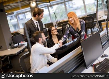 Young business people shaking hands in the modern office