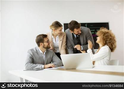 Young business people sitting at meeting table in conference room discussing work and planning strategy