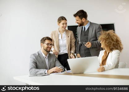 Young business people sitting at meeting table in conference room discussing work and planning strategy