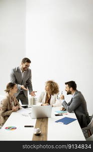 Young business people sitting at meeting table in conference room discussing work and planning strategy