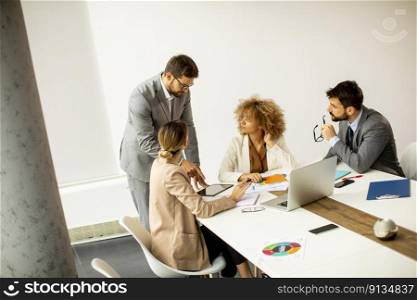 Young business people sitting at meeting table in conference room discussing work and planning strategy