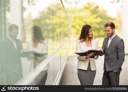 Young business people talking and viewing documents outdoor