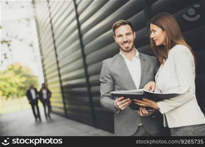 Young business people talking and viewing documents outdoor