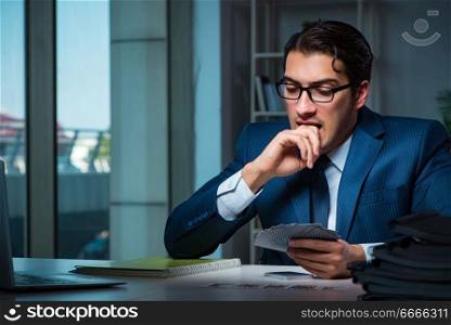 Young business playing cards late in office