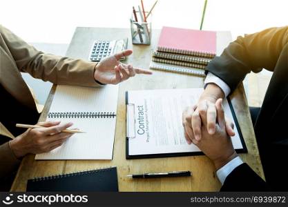 Young business team working with new startup project offering contract paper to his business partner for sign contract in conference room. discussing. Business accounting financial meeting concept.