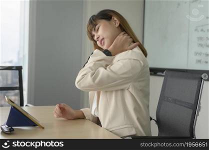 Young business woman feeling pain in neck and back in modern office