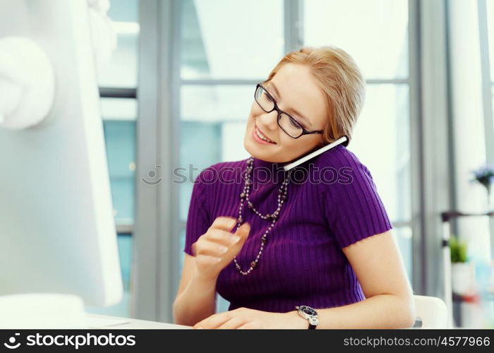 Young business woman in office holding mobile phone