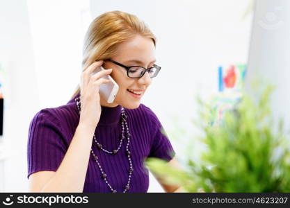 Young business woman in office holding mobile phone