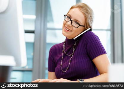 Young business woman in office holding mobile phone