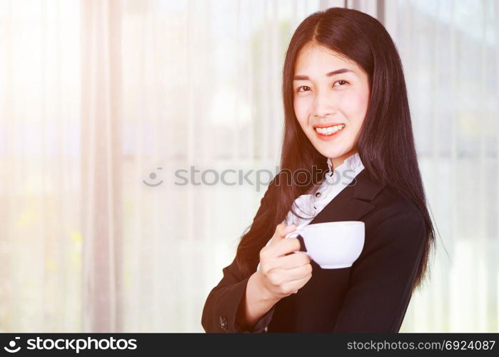 young business woman in suit with coffee or tea cup