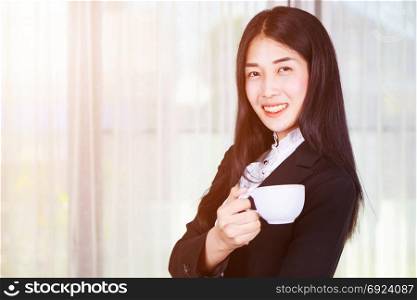 young business woman in suit with coffee or tea cup