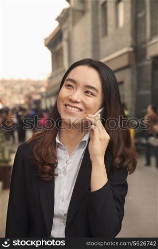 Young business woman on cell phone in Houhai, Beijing, China