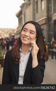 Young business woman on cell phone in Houhai, Beijing, China