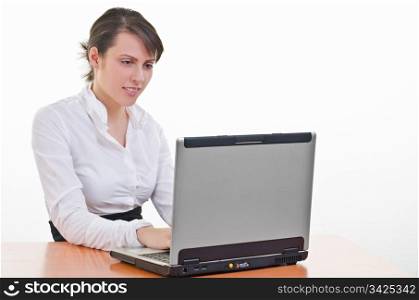 Young business woman sitting at desk and typing on laptop, high key, focus on eyes