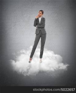 Young business woman standing on a cloud