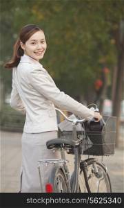 Young Business Woman standing with a Bicycle, Beijing, China