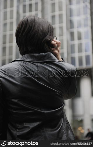 young business woman talking by phone on street