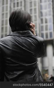 young business woman talking by phone on street