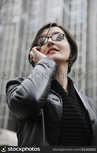 young business woman talking by phone on street