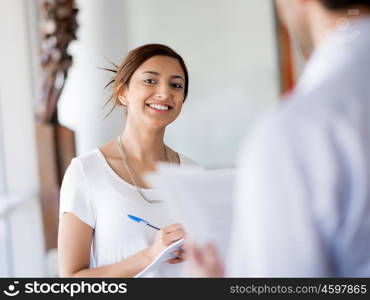 Young business woman talking to her collegue and smiling