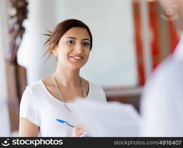 Young business woman talking to her collegue and smiling