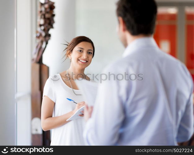 Young business woman talking to her collegue and smiling