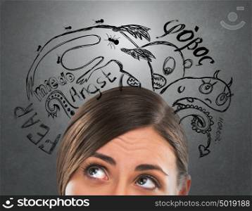 Young business woman thinking of her fearsand doubts closeup face portrait and sketches overhead