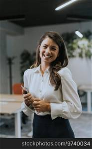 Young business woman with digital tablet standing in the modern office