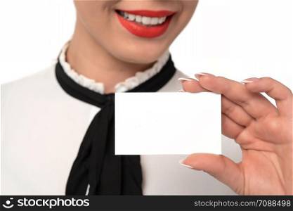 Young business woman with perfect smile and fingernails holds blank business card in close-up on a white background.