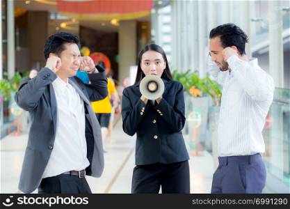 Young business woman working at the office, shouting and yelling in megaphone